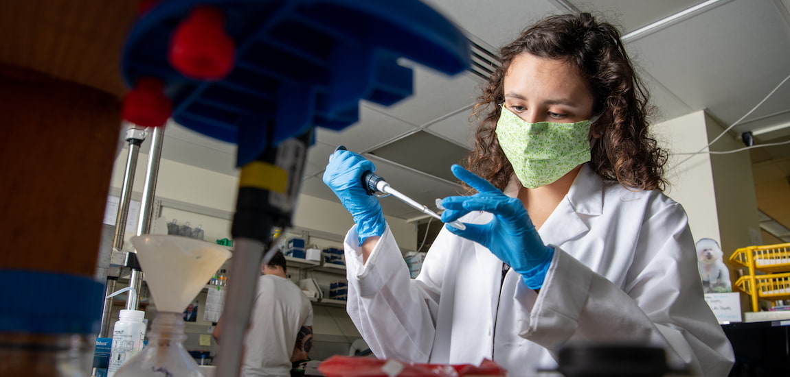女学生进行科学实验在实验室虽然戴着口罩